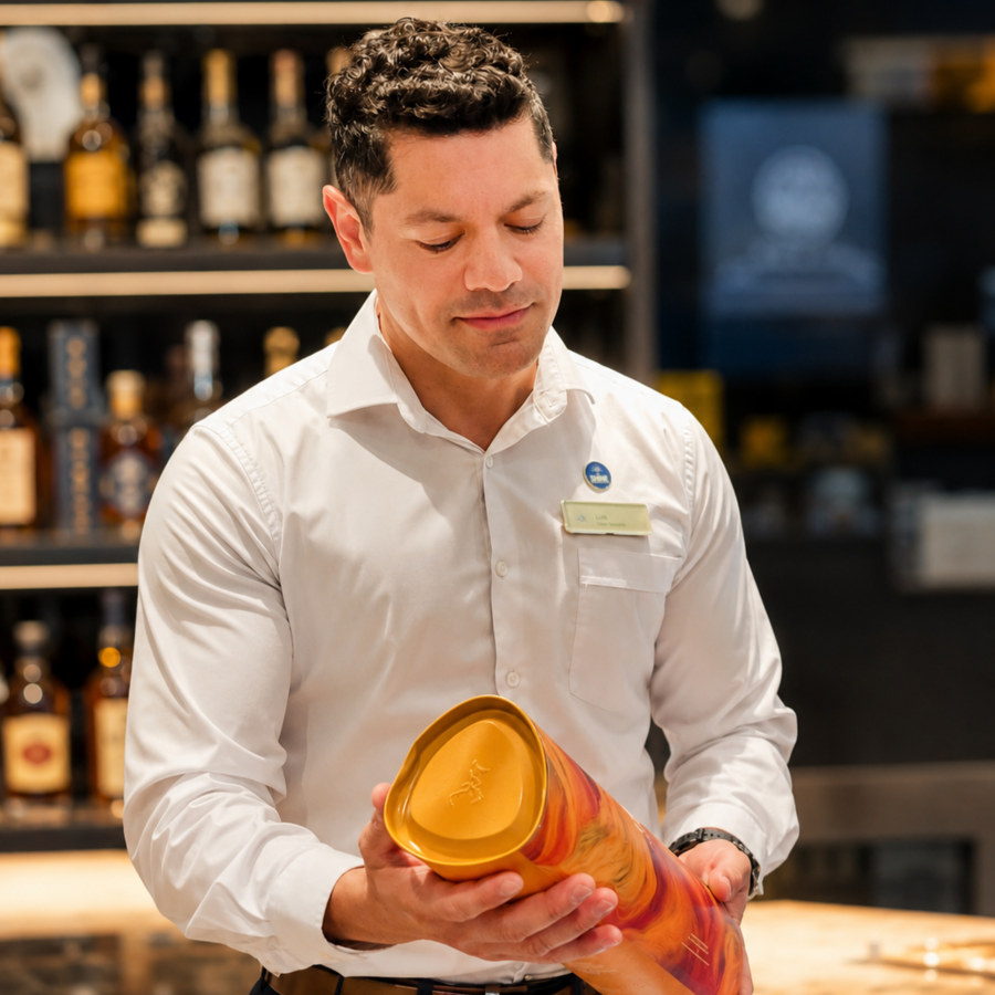 Liquor Specialist inspecting a premium spirits product in the onboard duty-free shop aboard a P&O Cruises ship. The image showcases retail careers, beverage expertise, guest service and luxury cruise retail opportunities at sea.
