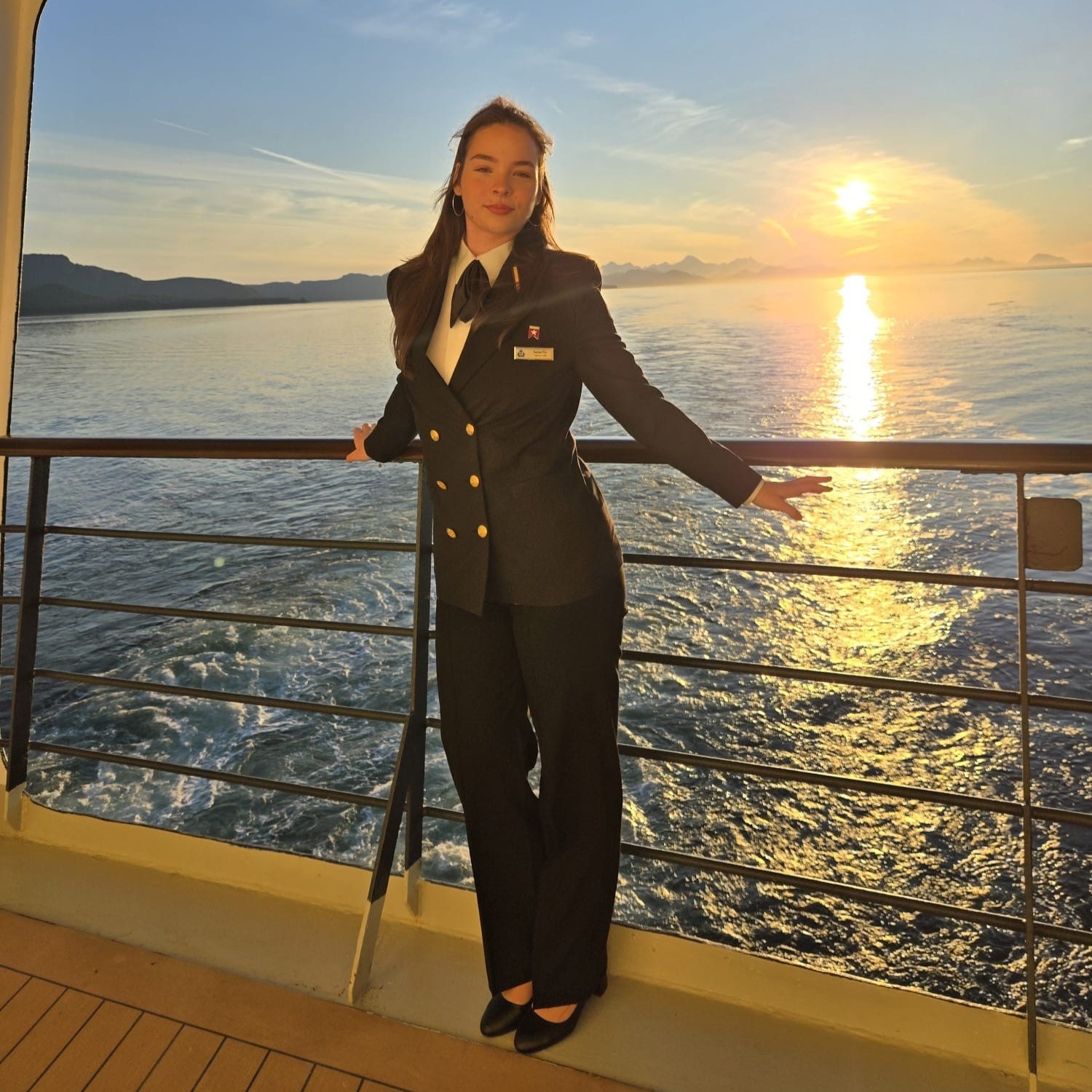 Colleague standing on the open deck of a P&O Cruises ship at sunset, overlooking the sea while enjoying life and work on board a cruise ship.